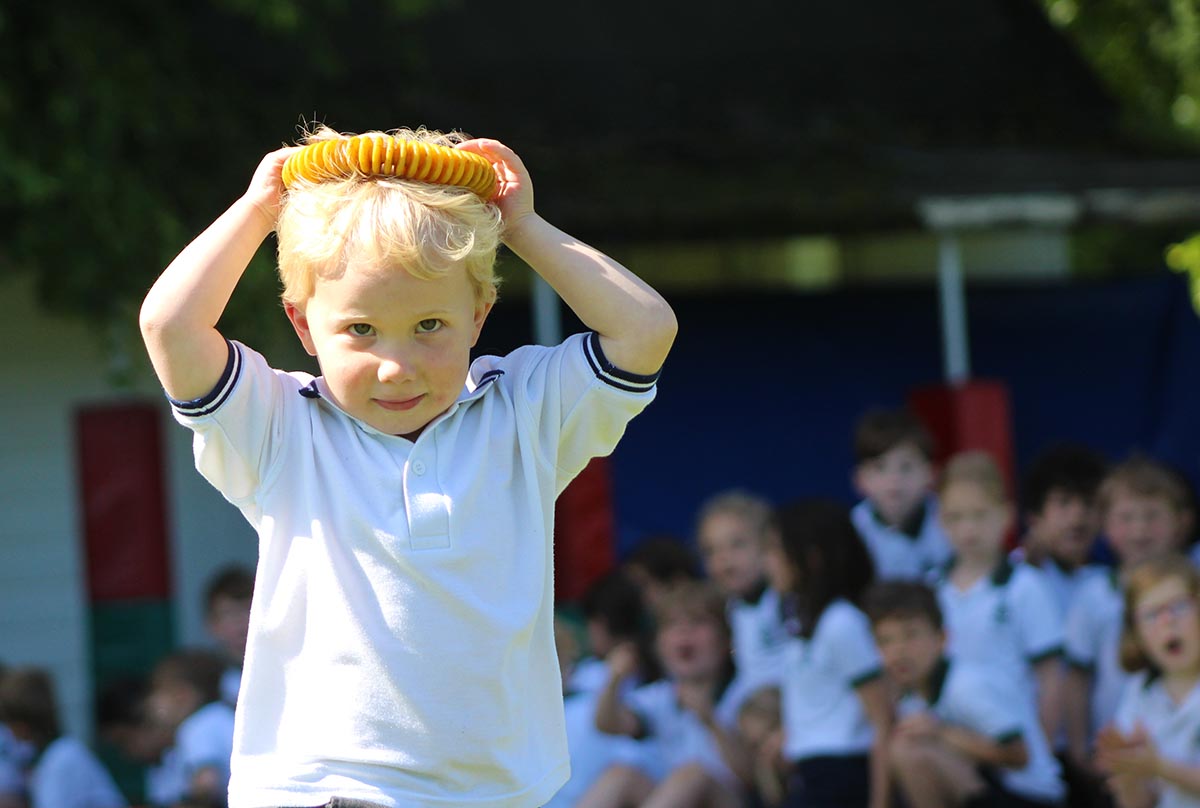 Child holding sports toy on head